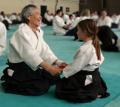 Tamura entrain de rire pratiquant le Kokyu Ho avec une enfant